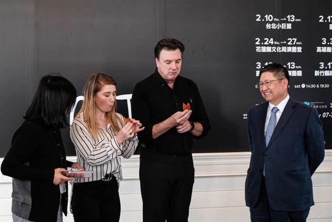 经典百老匯音乐剧《猫》将到新竹县演出，县长杨文科（左自右）回赠刻有客家谚语的保温瓶和竹县特产的柿饼，演员布莱德．利托及、多明尼克．汉米尔顿品尝柿饼，都说很美味。（罗浚滨摄）
