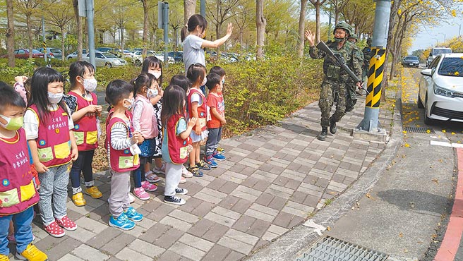 中部首梯新式教召嘉义县大林镇大埔美行军，巧遇幼儿园孩童，孩童们纷纷替阿兵哥加油打气。（张亦惠摄）