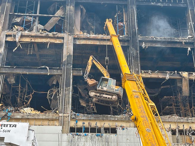 美福仓储18日吊挂4台小怪手进入仓储，准备清点并清运废弃物。（陈梦茹摄）