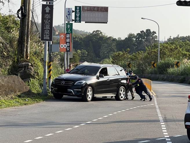 員警徒手將因為變速箱異常停在車道上的車輛推到路邊。（翻攝照片／李京昇苗栗傳真）