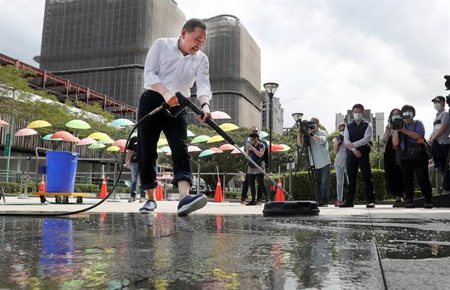 新北市长侯友宜出席在板桥435艺文特区举行的公益洗地板活动，换上主办单位提供的胶鞋认真清洗广场的每个角落。（郑任南摄）
