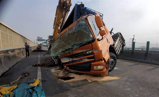 一辆载铸铁块的营曳引车，今天上午行经西滨快速道路南下梧栖段时，疑因天雨路滑及及重心不稳造成翻覆，真正肇事原因由警方调查中。（民眾提供）