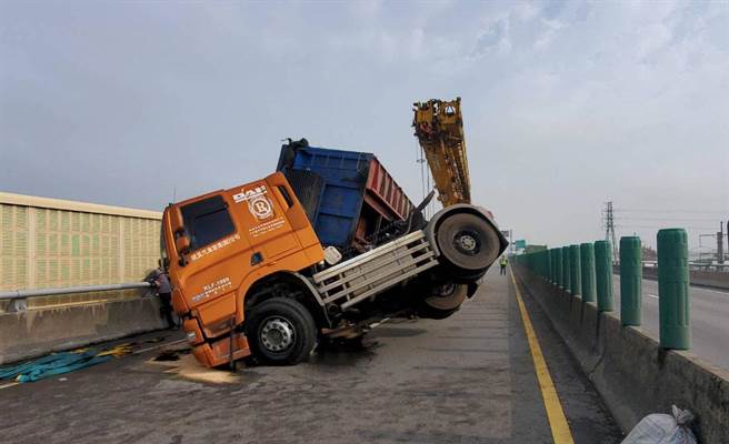 一辆载铸铁块的营曳引车，今天上午行经西滨快速道路南下梧栖段时，疑因天雨路滑及及重心不稳造成翻覆，真正肇事原因由警方调查中。（民眾提供）