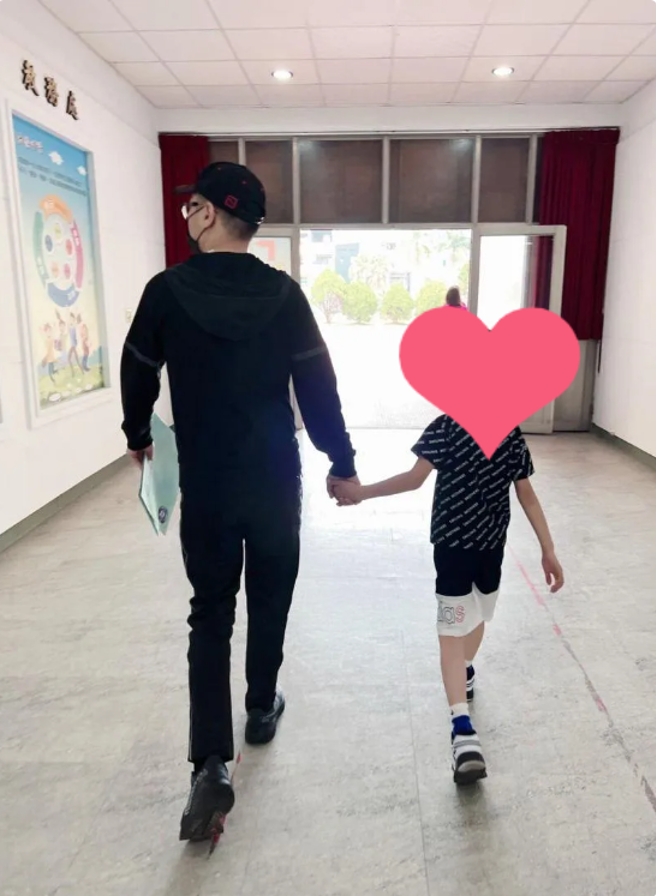 连千毅正牵着儿子的手，前往注册外语小学(图／连千毅 FB)