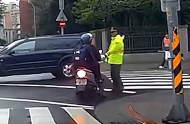 一名父亲骑机车载儿，企图红灯右转遭义交拦阻。（截自脸书《●【爆废公社二馆】●》）