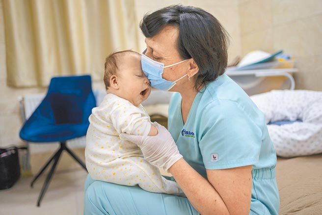 位于基辅的托儿中心，保姆正安抚着小婴儿。图／美联社