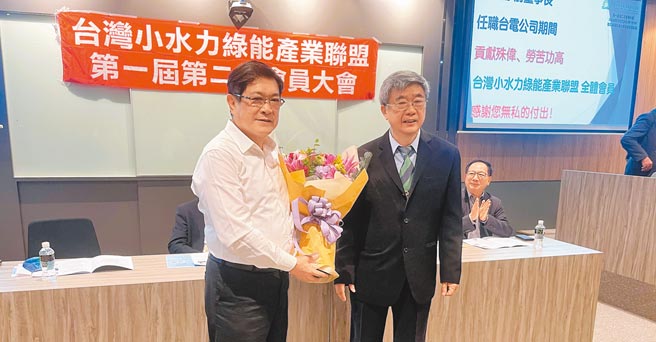 小水盟致赠鲜花，感谢永久会员杨伟甫（左）为台湾稳定提供能源的辛劳服务；右为理事长洪正中。图／小水盟提供