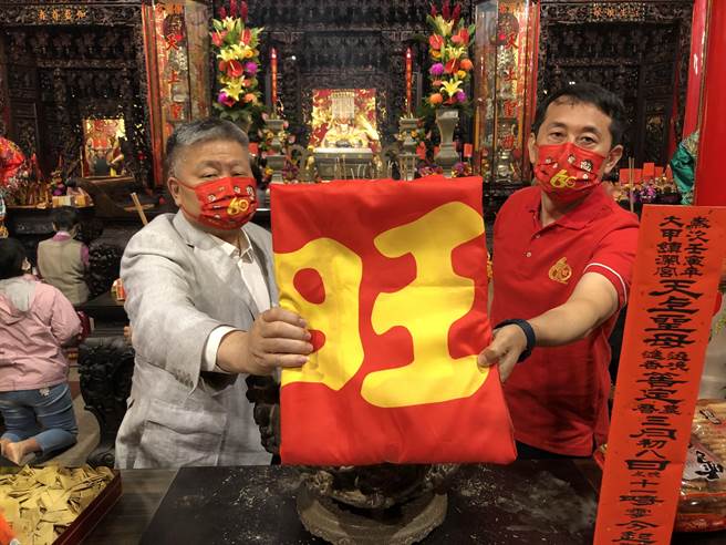 鎮瀾宮董事長顏清標（左）與宜蘭食品副總經理鍾永富（右），一起將象徵旺旺精神的「旺旗」過爐，恭請媽祖神威加持。（陳世宗攝）