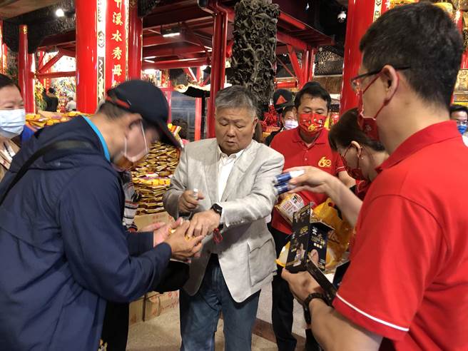 鎮瀾宮董事長顏清標於過爐儀式後，分享旺旺食品及水神給媽祖信眾，大家吃平安又保平安。（陳世宗攝）