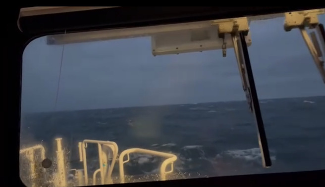 海巡署所属3596艇抵达现场，因海象不佳，海巡人员于艇内瞭望搜寻台籍船员。（海巡署舰队分署提供）