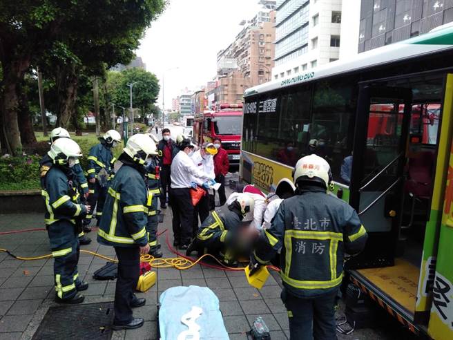 警消將困在公車底的傷者救出送醫，所幸沒有生命危險。（翻攝照片／林郁平台北傳真）