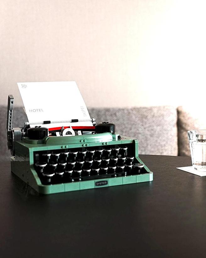 （台北時代寓所攜手台灣樂高推出LEGO樂高主題房，《普普復古》尊榮客房中放置經典的薄荷綠復古樂高打字機，重現1950年代的通訊風格。圖／台北時代寓所提供）