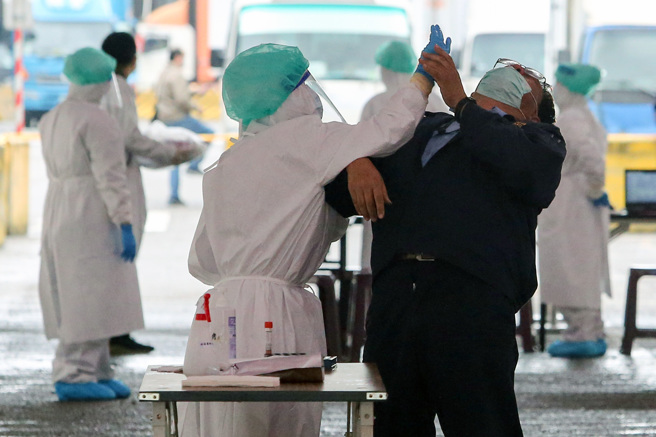 本土今增15例確診 ，其中有13例屬於高雄職場群聚相關。圖為民眾接受採檢的畫面。（本報系資料照）