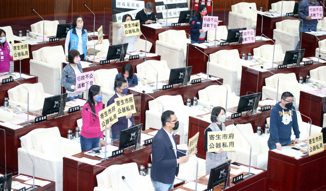 国民党台北市议员24日在市政质询时集体举牌抗议，抨击北市劳动局长陈信瑜行政不中立，2月间与工会新春茶会时替副市长黄珊珊助选。（姚志平摄）