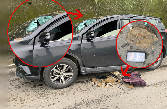 休旅車被落石砸破擋風玻璃，駕駛當場開放性骨折；事故照中，休旅車玻璃破出驚悚大洞，一旁的車身零件還有血跡。（翻攝照片）