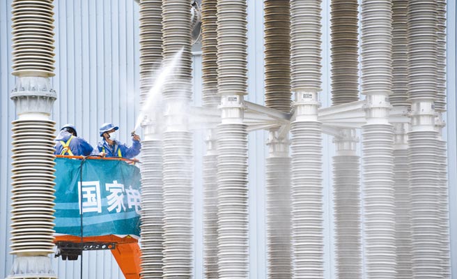 大陆发布《「十四五」现代能源体系规画》，强调加速能源转型，2025年非化石能源发电量比重达39％。图为大陆国家电网北京市电力公司延庆换流站的员工清洗绝缘立柱。（新华社）