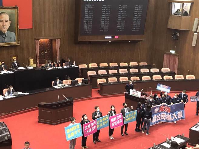 民眾党团、国民党团手持「赞成18岁公民权」告示牌。（赵婉淳摄）