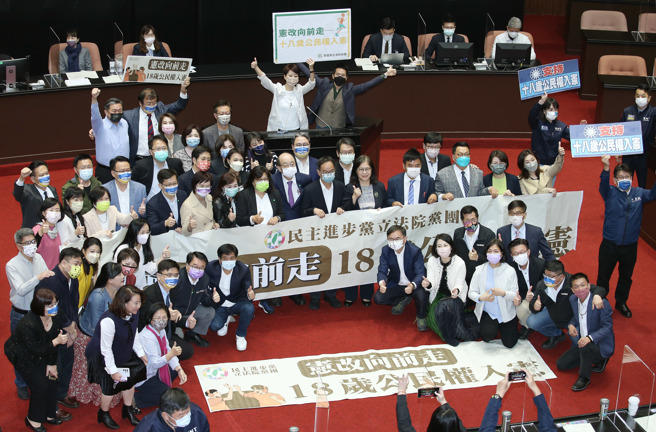 立法院25日院會三讀通過18歲公民權修憲案，民進黨團在議場內拉布條拍照紀念。（姚志平攝）