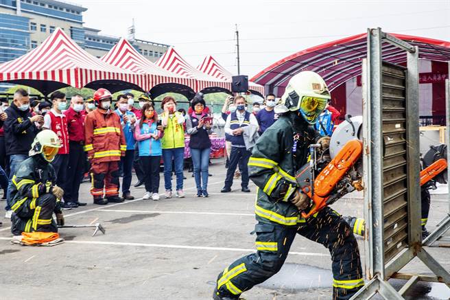 新竹縣新進女消防員持電鋸，驗收破壞鐵捲門進行救災。（羅浚濱攝）