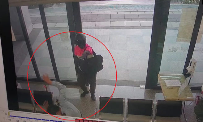 高雄三信銀行今(25)日發生搶案，男子持槍與辣椒水搶劫，保全被噴灑辣椒水後踉蹌倒地，嫌犯行搶得手5萬餘元。（警方提供）