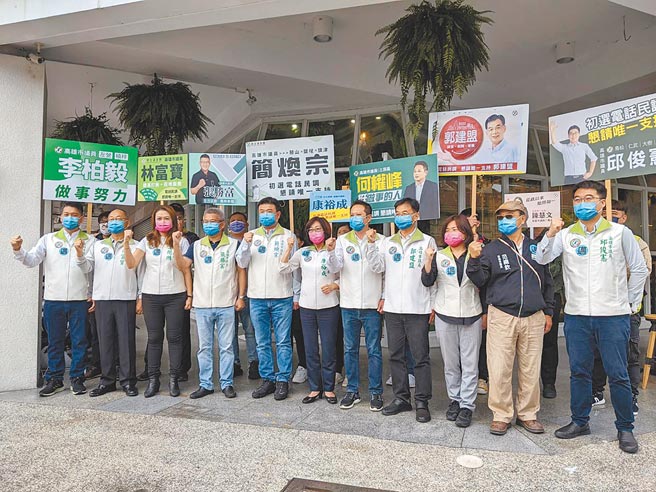 前高雄巿議會議長康裕成（中）率10位現任議員24日到民進黨高雄巿黨部聯合登記，握拳高喊「連任拚過半、高雄大邁進」。（曹明正攝）