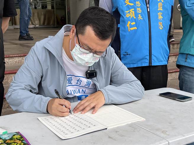 台北市议员罗智强因被桃园市长郑文灿点名错把「新屋」写成「新乌」，26日带着特制小学生生字簿赴桃市府前罚写千遍。(蔡依珍摄)