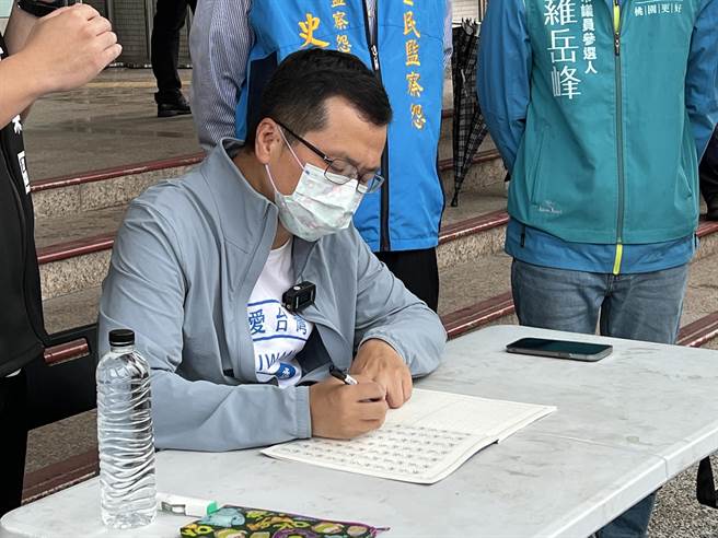台北市议员罗智强因被桃园市长郑文灿点名错把「新屋」写成「新乌」，26日带着特制小学生生字簿赴桃市府前罚写千遍，写到手酸一度改用左手罚写。(蔡依珍摄)