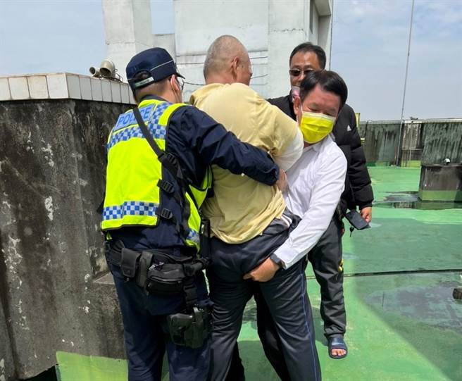 警方迅速将人抱下女儿墙，结束一场惊魂记。(警方提供)