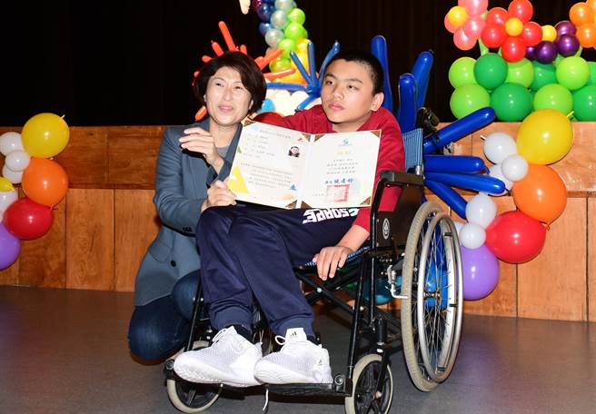 太平国小罗余豪（右）乐观进取，获选为模范儿童，由县长饶庆铃（左）颁奖表扬 。（庄哲权摄）