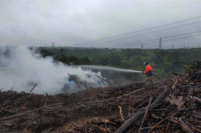关西农地堆置大量废木材因沼气引发闷烧火警，消防局持续灌救中。（新竹县消防局提供／罗浚滨新竹传真）