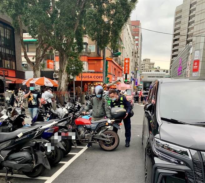 停在停車格內的機車騎士，因後方被擋道無法駛離，保大員警合力搬移機車、協助脫困。(翻攝照片／林郁平台北傳真）