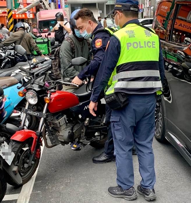 停在停車格內的機車騎士，因後方被擋道無法駛離，保大員警合力搬移機車、協助脫困。(翻攝照片／林郁平台北傳真）