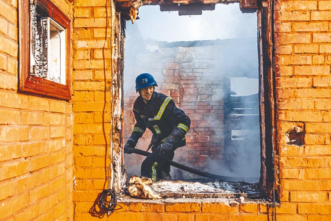 俄烏戰爭已延燒逾一個月，美國國防部掌管政策的次長卡爾（Colin Kahl）24日預言，經過這場衝突後俄羅斯將變得更羸弱。圖為烏克蘭消防員23日在基輔市一處受損的房屋內工作。（新華社）