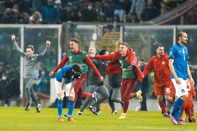 北馬其頓獲勝瞬間板凳球員衝入場內慶祝，義大利老隊長基耶澧（右）則一臉茫然的呆立現場。（美聯社）