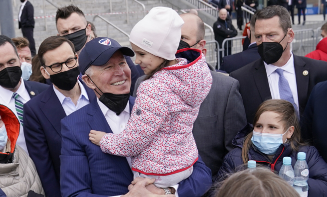 美国总统拜登26日情绪激动地造访位于波兰华沙的乌克兰难民营，抱起其中1名小女孩。（美联社）