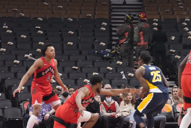 可以看到比赛虽在进行，全副武装的消防员已经进场疏散观眾。(美联社)