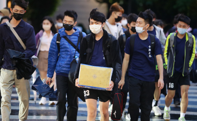 国内疫情升温，假日逛街的民眾仍然紧戴着口罩不敢松懈，台湾何时能解封还未知。（季志翔摄）