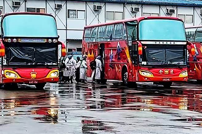 在大潭电厂确诊泰籍移工，穿上防护衣后上游览车，分送医院或集中检疫所。（民眾提供／罗浚滨新竹传真）