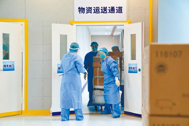 上海49歲護理師24日氣喘發作送醫急救遇防疫清消遭拒，轉診不及身亡，醫院卸責引起批評。圖為25日上海集中隔離點的醫護人員運送物資。（新華社）