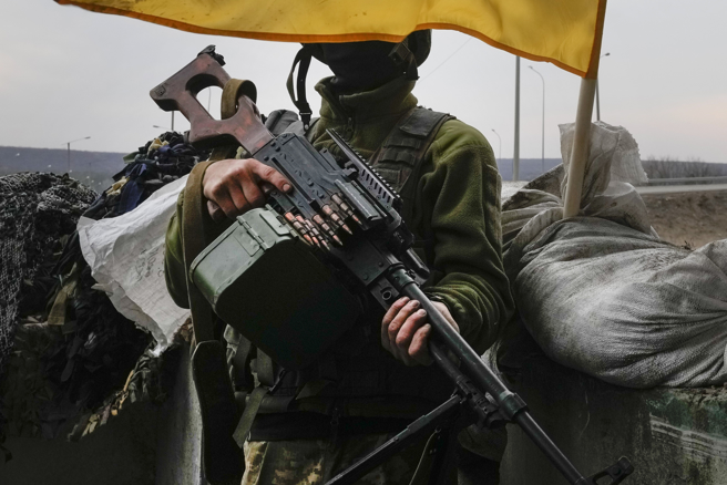 乌克兰军人26日拿着机关枪，在第二大城哈尔科夫（Kharkiv）的前线守备。（美联社）