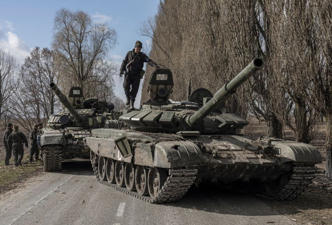 乌克兰部队在首都基辅郊区卢基亚尼夫卡（Lukyanivka）掳获俄军坦克后，1名乌军爬上坦克。（路透）