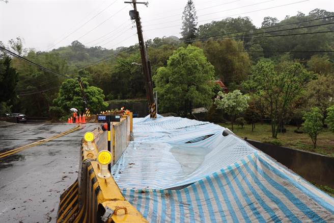 县府派员在崩塌裸露处施盖帆布避免崩塌持续恶化。（李京升摄）