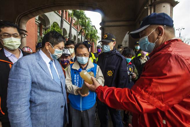 關西鎮長劉德樑（右）拿出在北山里溪流取的汙濁用水給縣長楊文科（左），指廢棄土汙染當地水源。（羅浚濱攝）