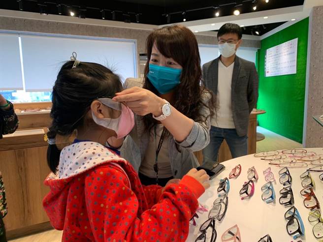 中嘉寬頻北健總經理許巧妮(中)幫學童挑眼鏡。(翻攝照片／蔡依珍桃園傳真)