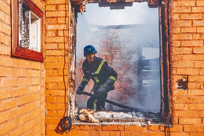 图为3月23日，消防员在乌克兰基辅市一处受损的房屋内工作。 （新华社）