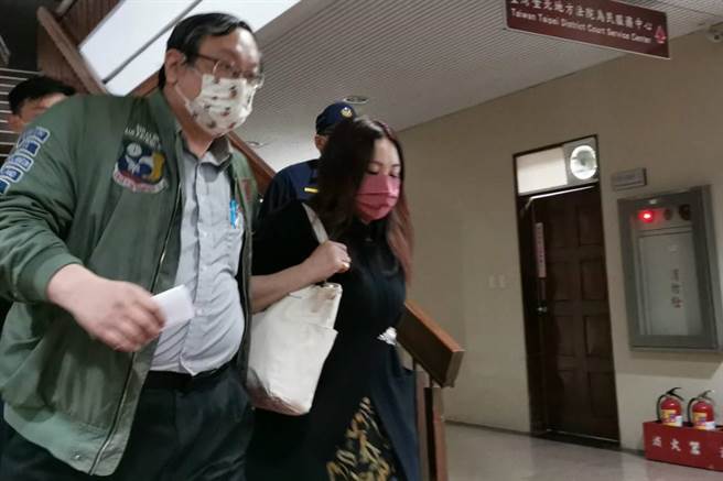 北市殯葬處副處長王文秀（紅色口罩者）60萬交保離開北院。(蔣永佑攝)