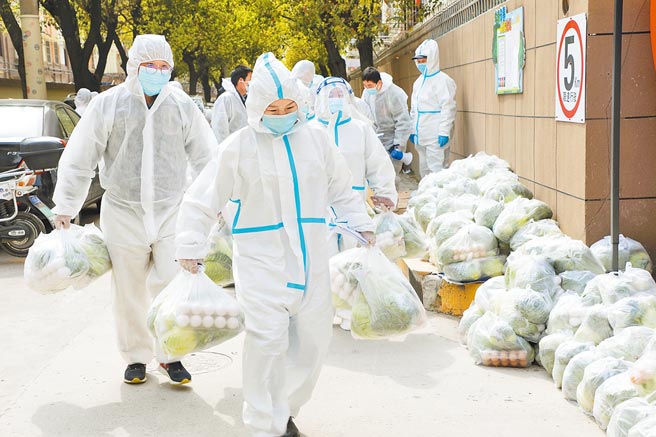 图为上海奉贤区一处社区的防疫志工为居民送菜。（新华社）