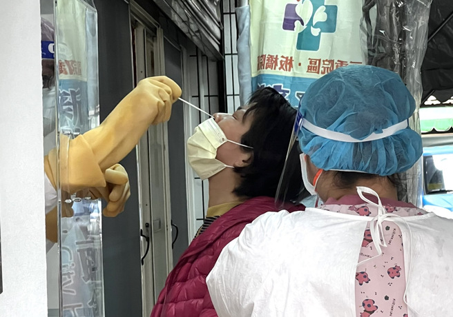 图为新北市中和区某公寓爆7例确诊，民眾前往快筛站採检。（范扬光摄）