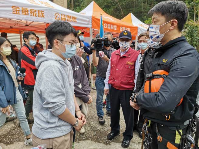 蔡进国的女儿（灰衣者）30日出面不断鞠躬致谢，语带哽咽地说「谢谢大家帮我把爸爸带回家」场面相当哀戚。（消防局提供）