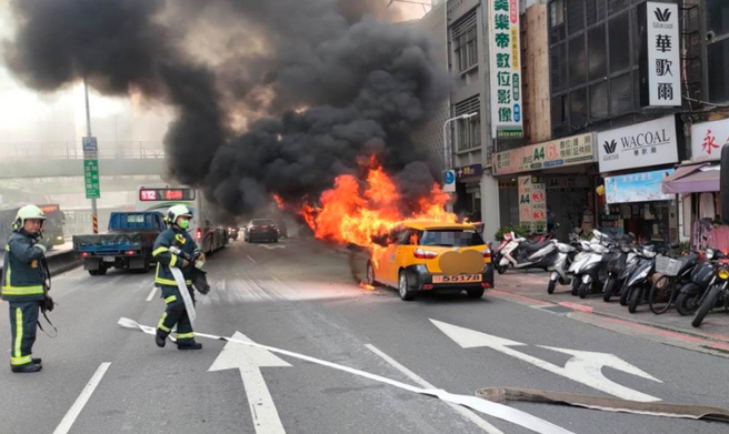 許姓計程車駕駛聞到異味，下車以滅火器撲滅未果，整輛車引擎蓋冒火。（民眾提供）